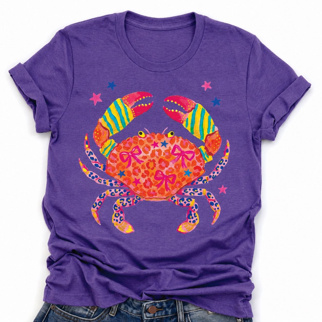 Purple summer graphic tee with bright boujee crab design featuring colorful claws, stars, bows, and leopard print details.