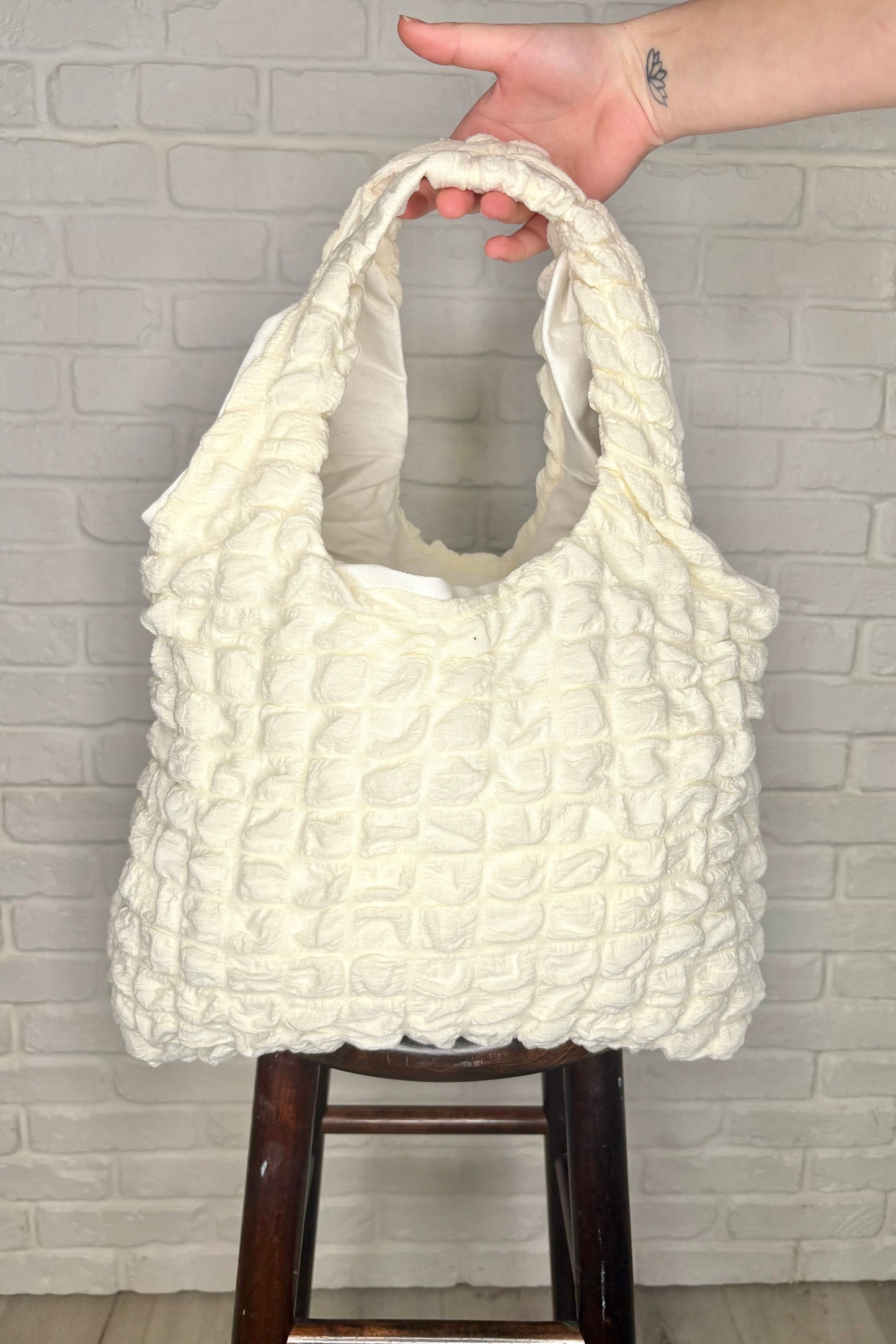 A cream-colored, textured tote bag