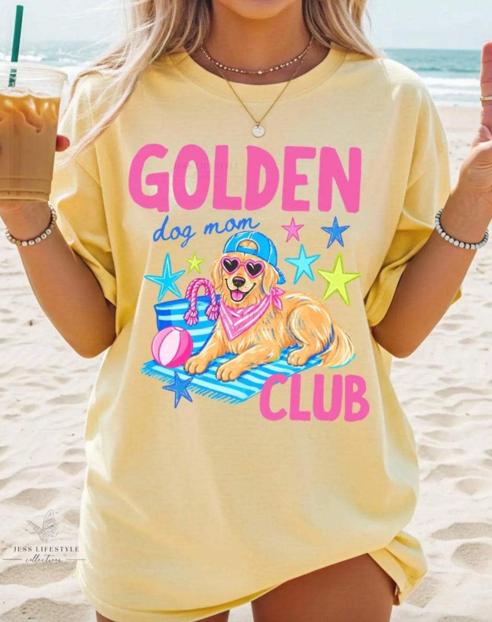 Golden Dog Mom Club butter yellow shirt with pink lettering, golden retriever wearing sunglasses, beach towel, stars, tote bag, and beach ball design.