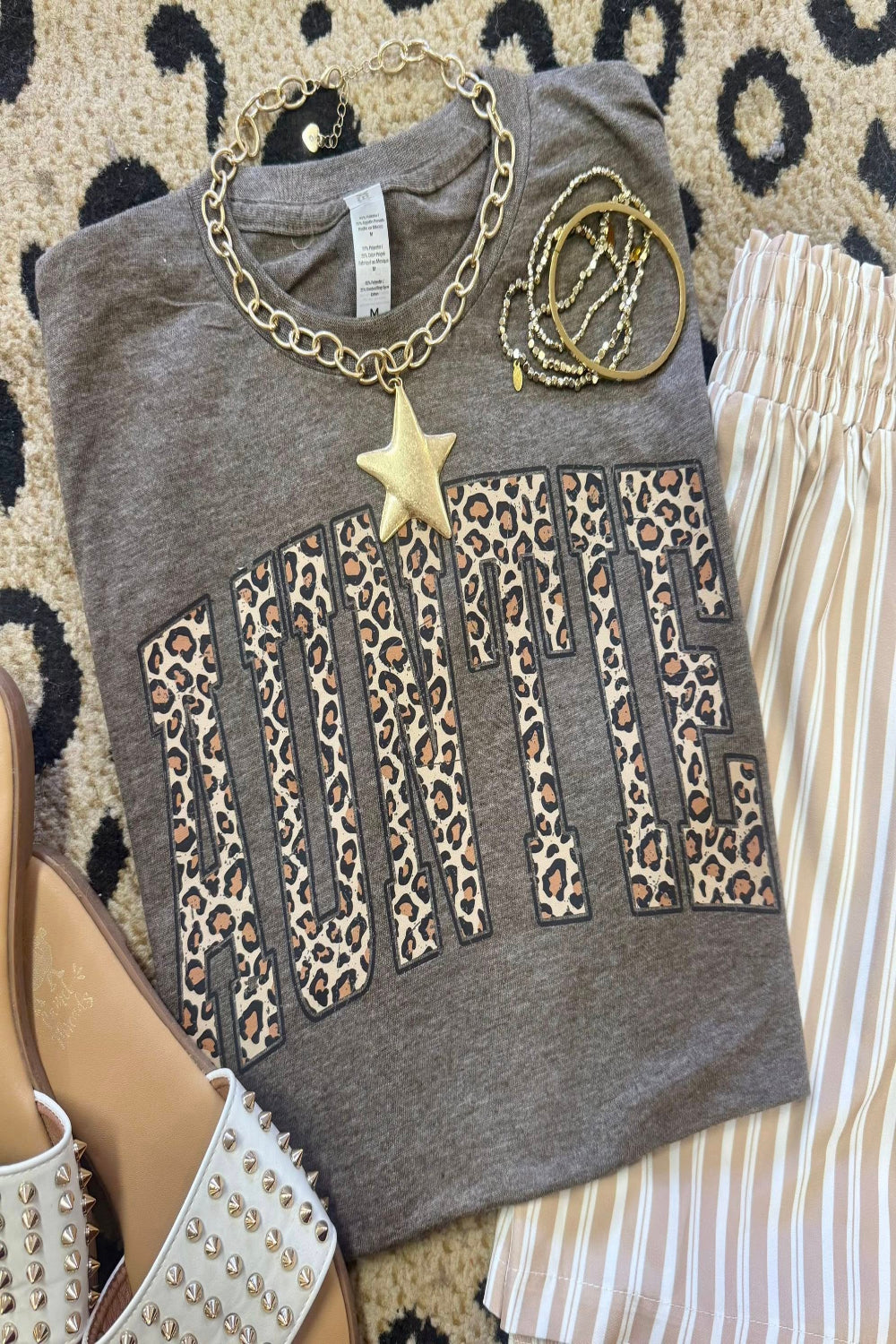 Leopard Auntie graphic tee on heather brown Tultex shirt styled with bracelets and neutral striped pants for a trendy Mother’s Day outfit.