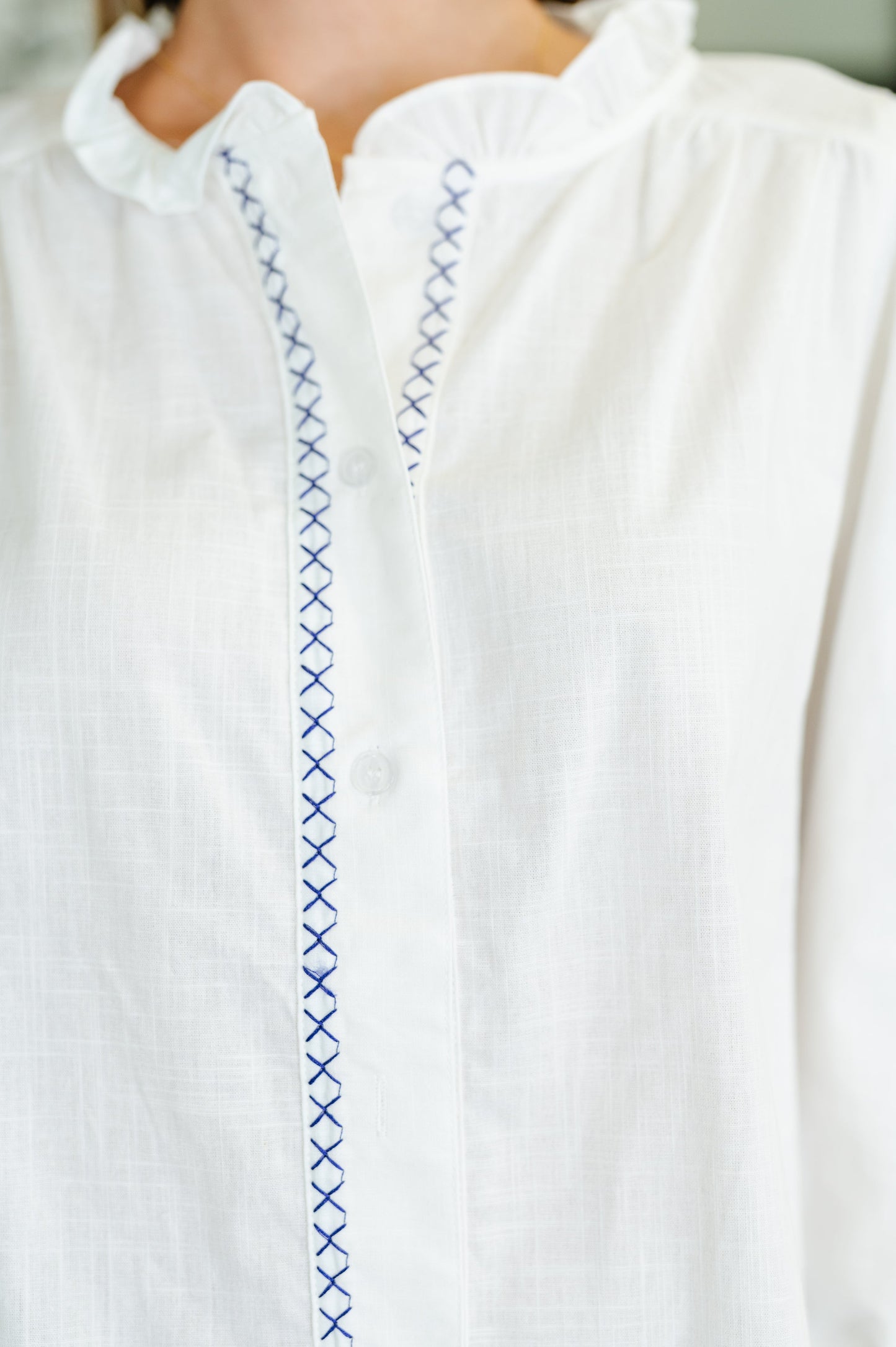 White, long sleeve, button down blouse with blue embroidery