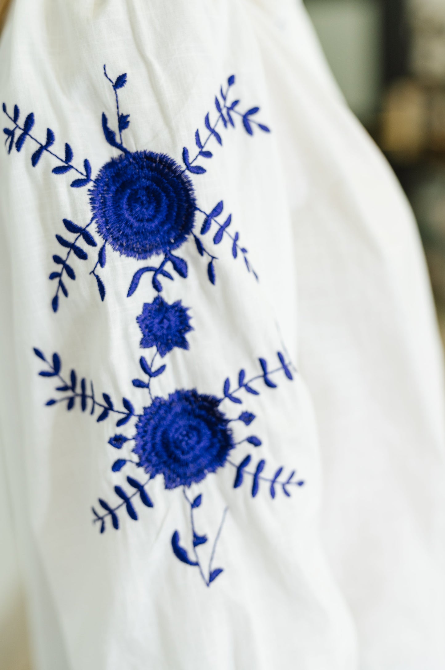 White, long sleeve, button down blouse with blue embroidery