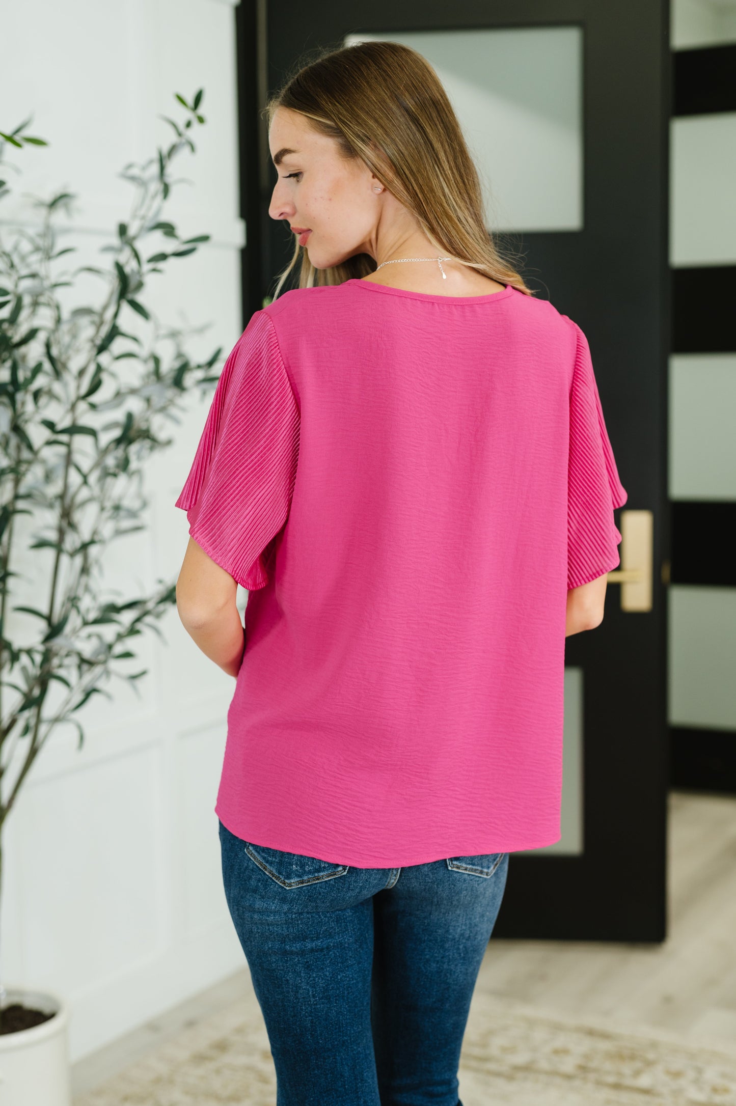Pink ruffle sleeve top with a round neckline and short, pleated sleeves.
