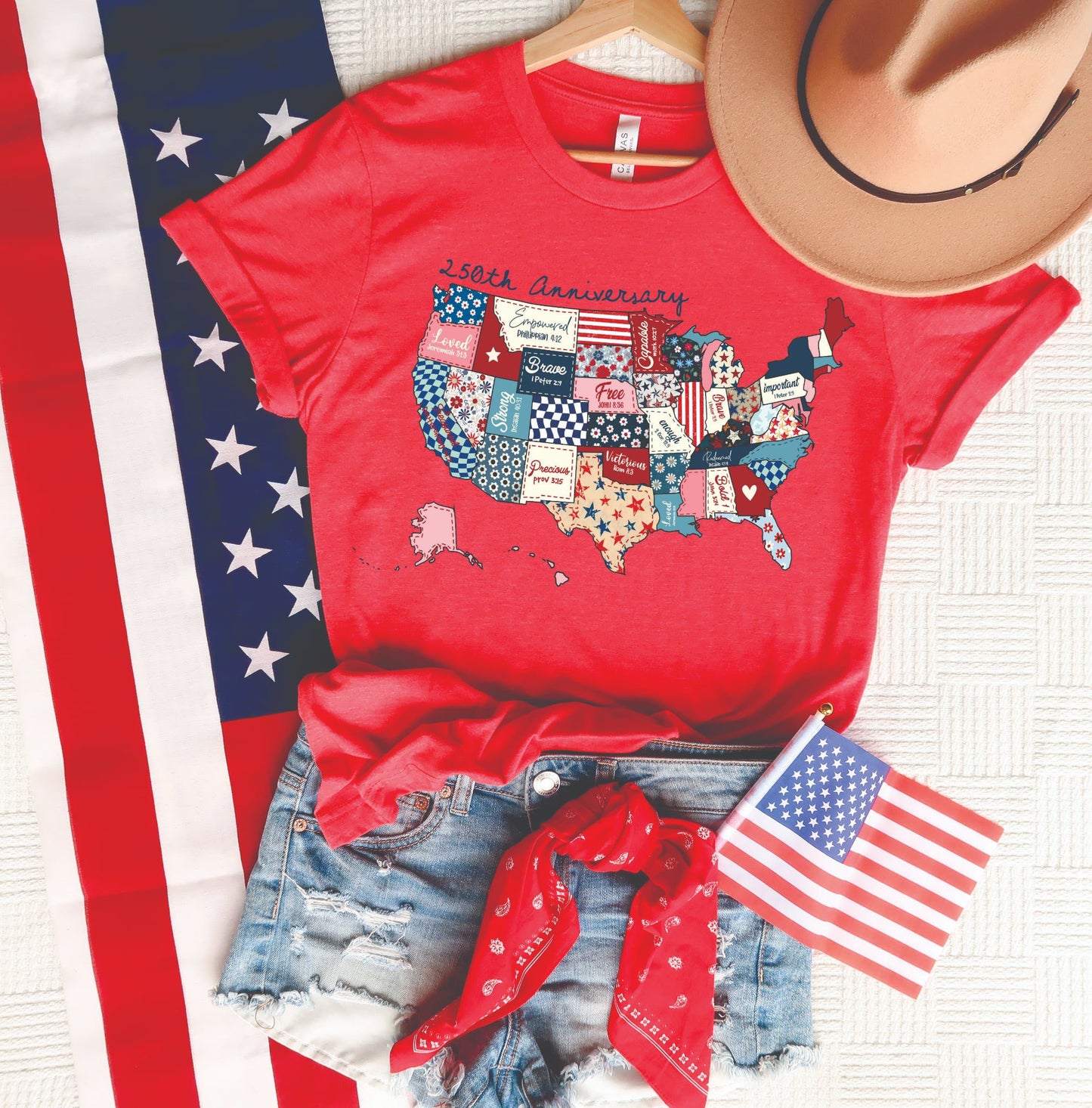 250th Anniversary patriotic USA map graphic tee on a red Tultex unisex shirt styled with denim shorts, American flag, red bandana, and tan hat.