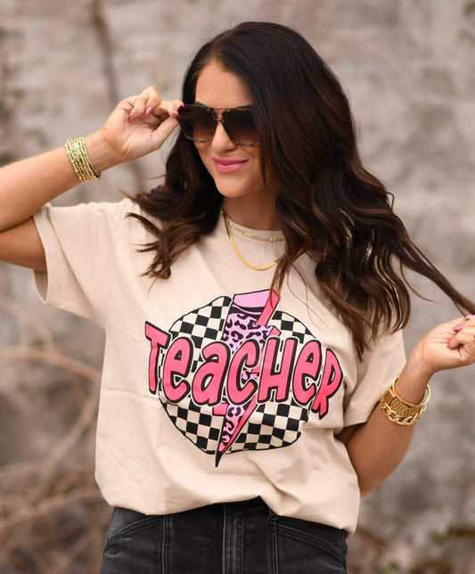 Boutique teacher graphic tee in tan featuring pink lightning bolt with leopard print and checkerboard design