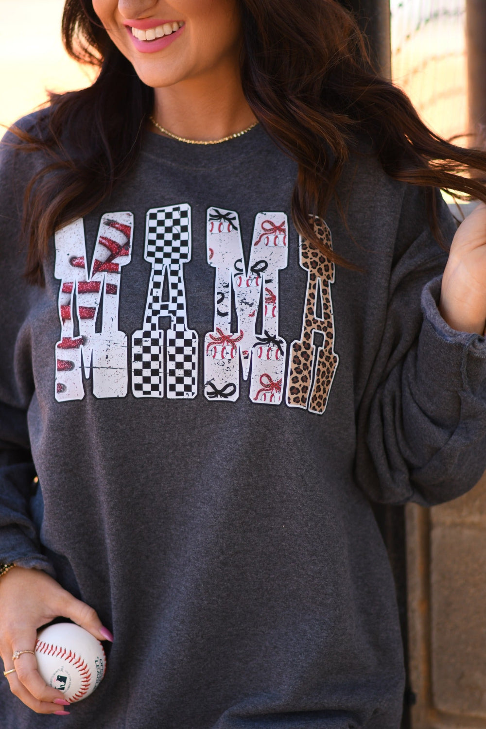 Baseball Mama heather charcoal unisex tee and sweatshirt with bold baseball print lettering, worn with embroidered baseball stitch snapback hat