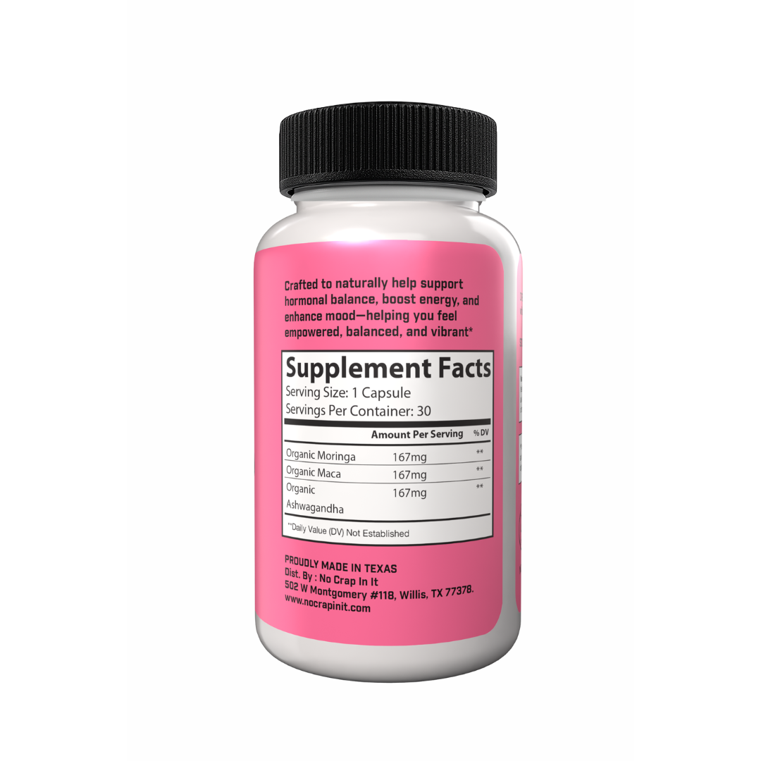 A bottle of 'No Crap In It' Womanhood Super Vitamin Supplement with pink label, black cap, and text indicating optimized hormonal balance, increased energy, and enhanced mood and relaxation.