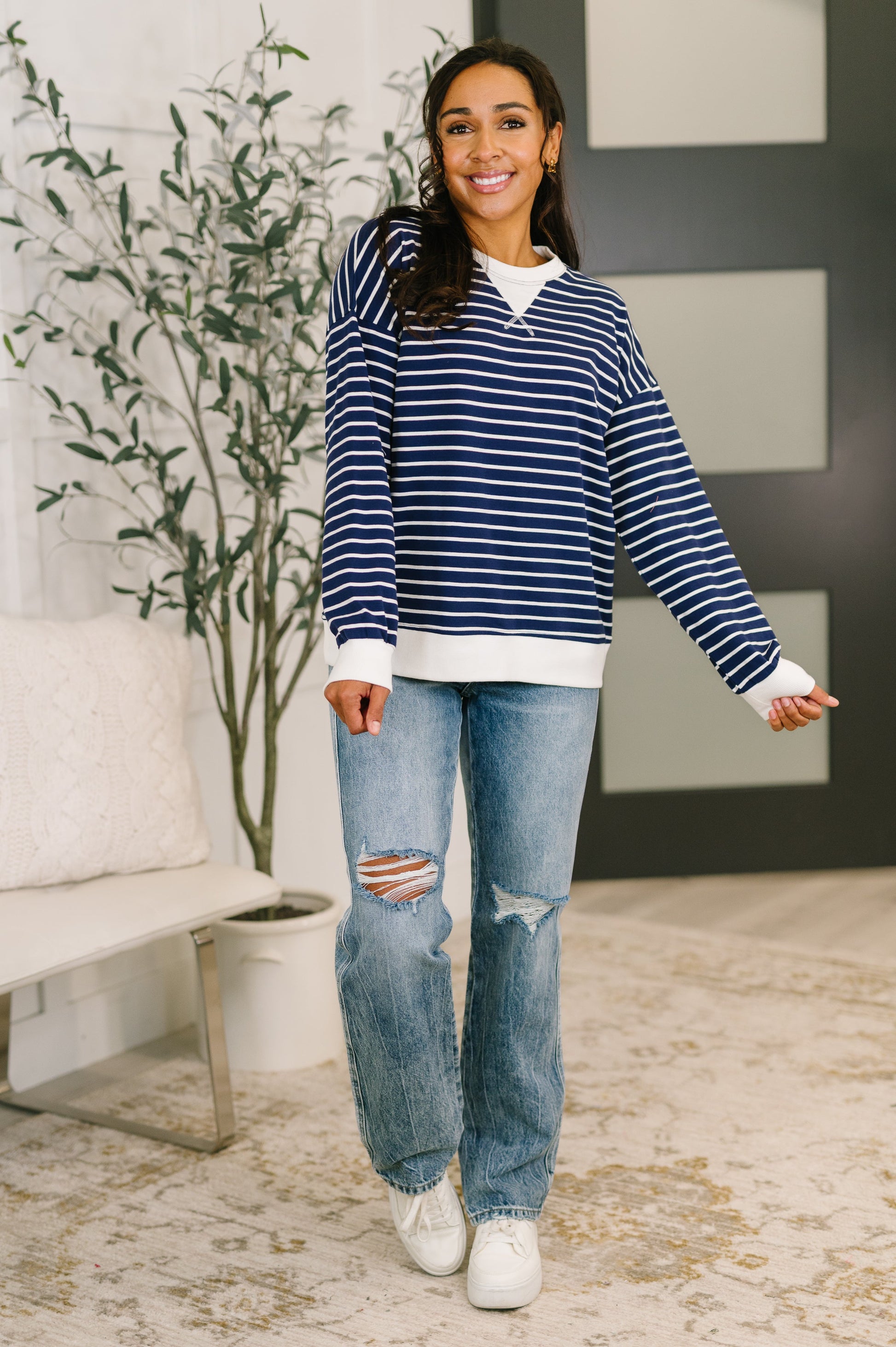 Model wearing Zenana Almost Therapeutic Drop Shoulder Pullover in Navy with light wash jeans and white sneakers