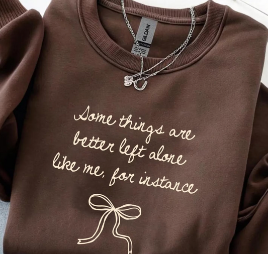 Brown sweatshirt with text and a bow design, featuring a Gildan tag.