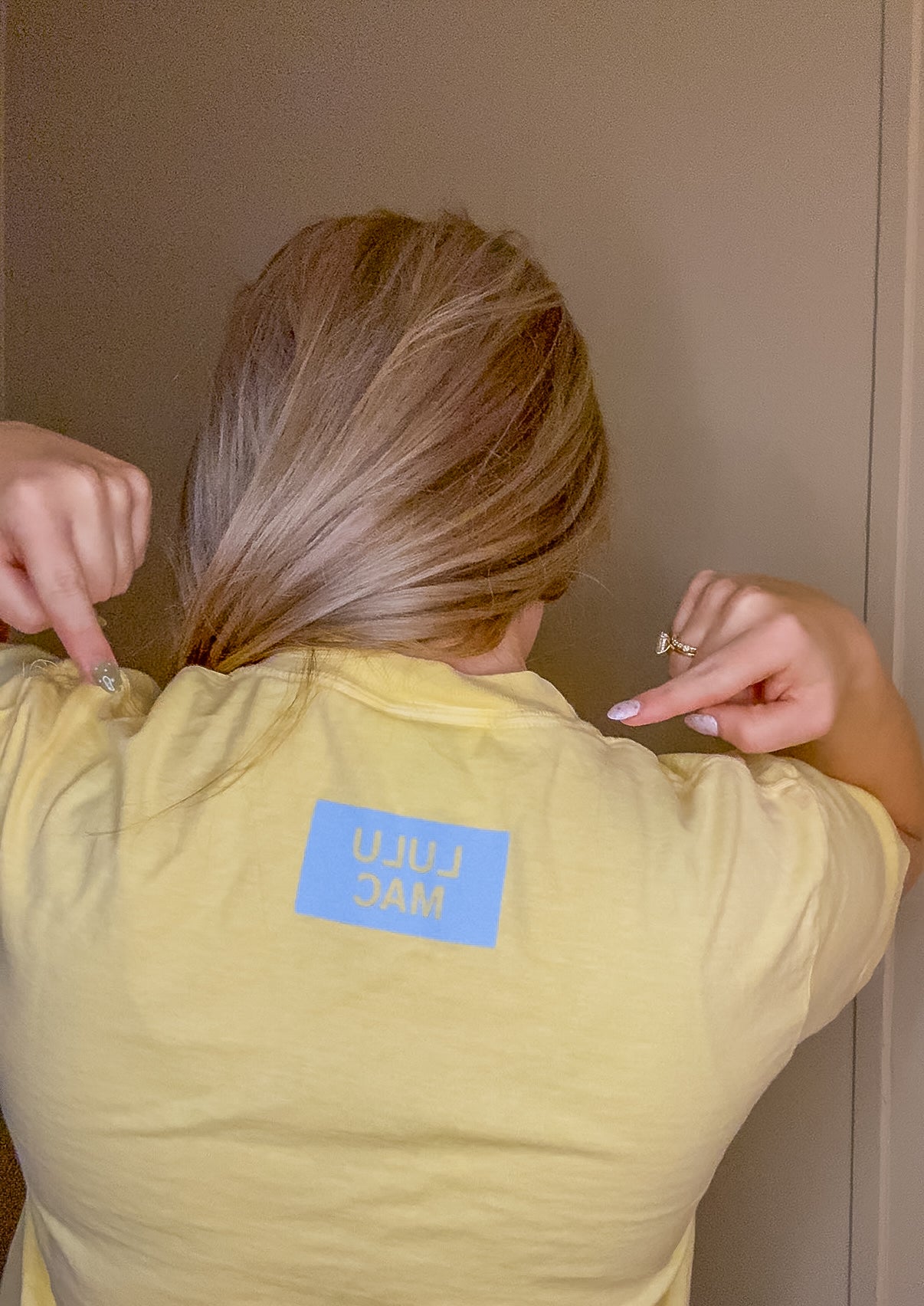 Blonde woman wearing butter yellow Comfort Colors t-shirt with blue polka dot Lulu Mac graphic, styled casually with denim