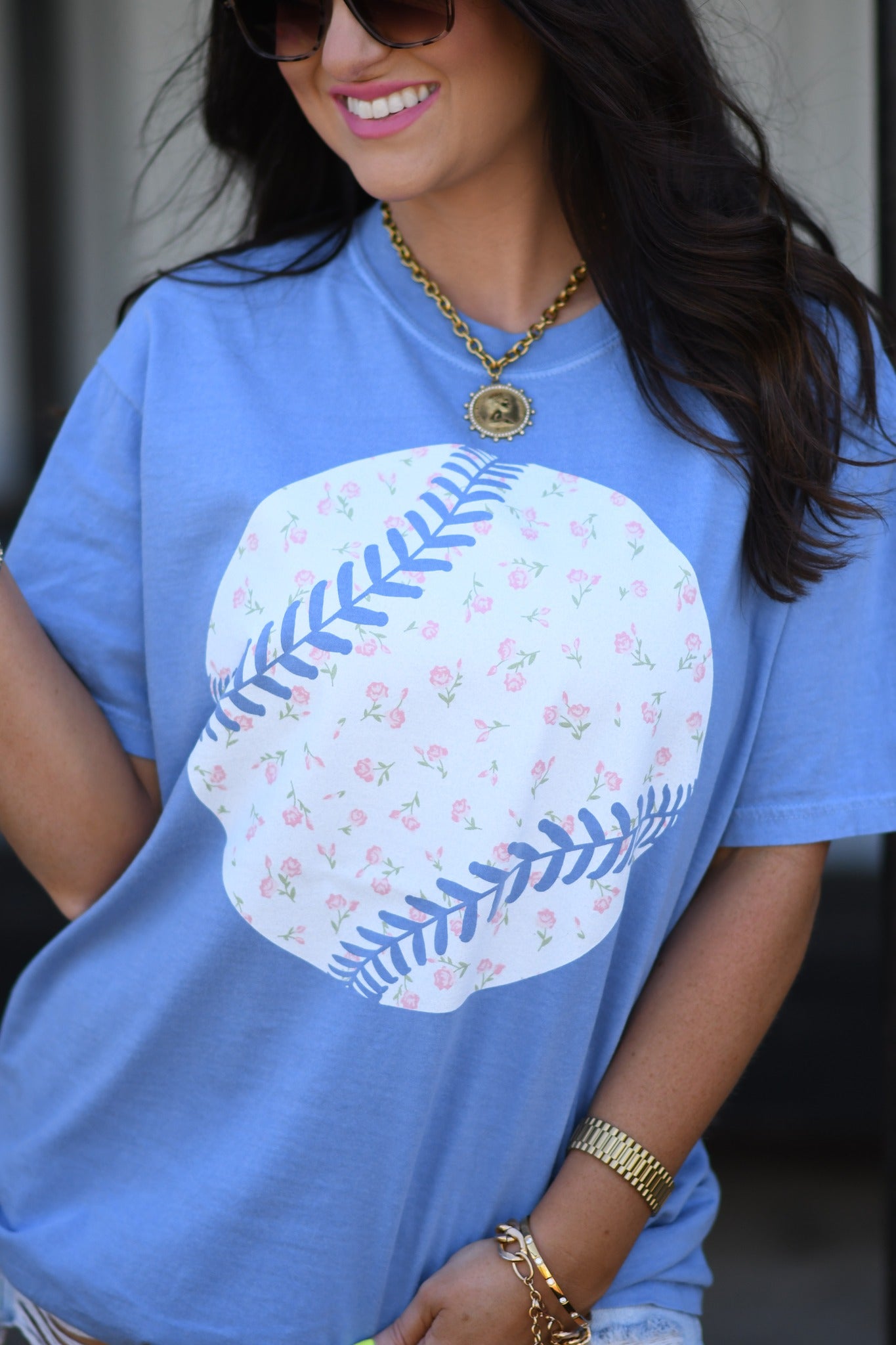 Woman wearing washed denim floral baseball graphic tee with denim shorts and sunglasses, styled for spring and summer casual outfit