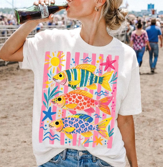 Colorful striped trout graphic tee with bright fish, starfish, waves, and coastal summer design on a white shirt