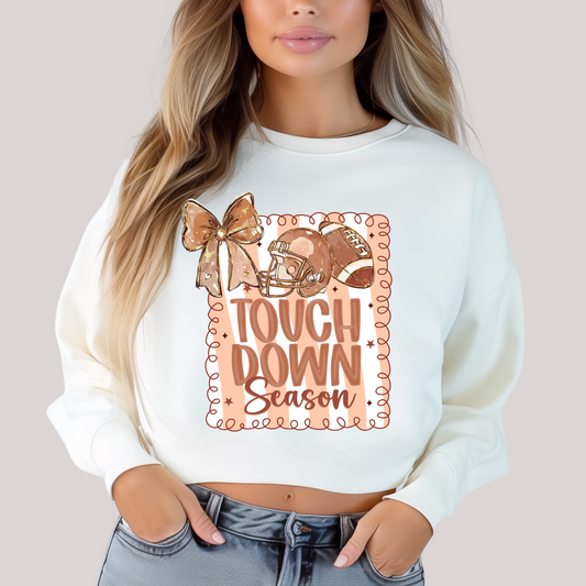 White sweatshirt with 'Tough Down Season' graphic design.