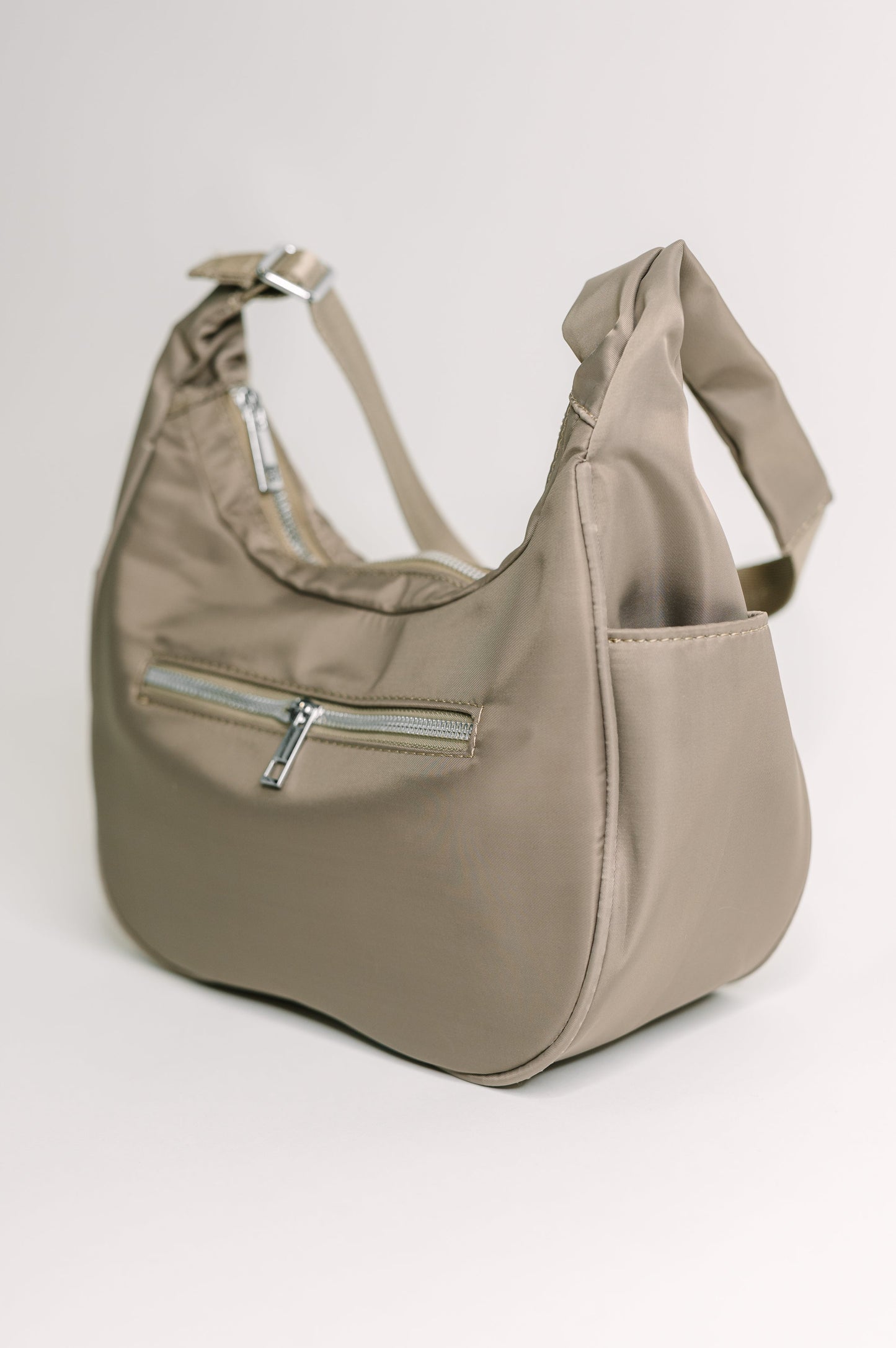 Easy Clean Nylon shoulder bag
Height: 6.5” Width: 10 3/4” Depth: 4”
Adjustable Strap 22 1/4”
Silver Hardware
Back Zipper Pocket 7” X 4”
Inside Patch Pocket
Inside Zipper Pocket