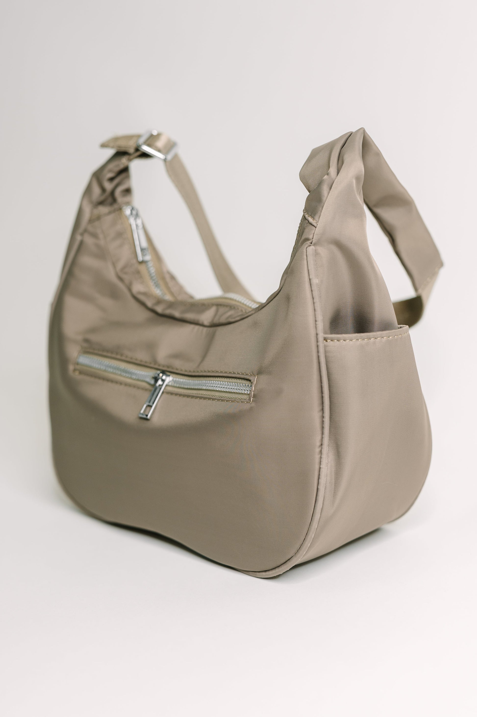 Easy Clean Nylon shoulder bag
Height: 6.5” Width: 10 3/4” Depth: 4”
Adjustable Strap 22 1/4”
Silver Hardware
Back Zipper Pocket 7” X 4”
Inside Patch Pocket
Inside Zipper Pocket