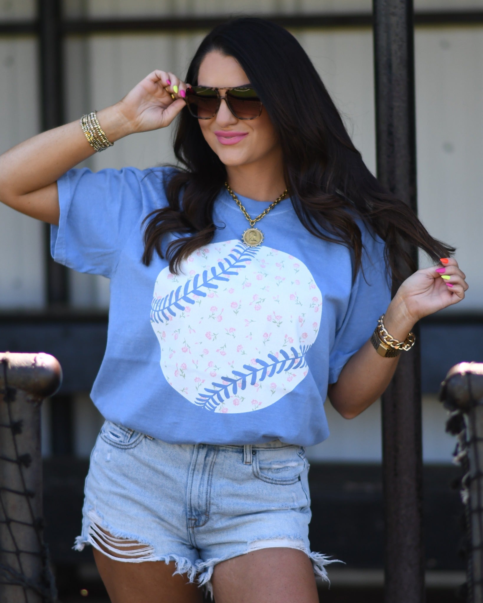Woman wearing washed denim floral baseball graphic tee with denim shorts and sunglasses, styled for spring and summer casual outfit