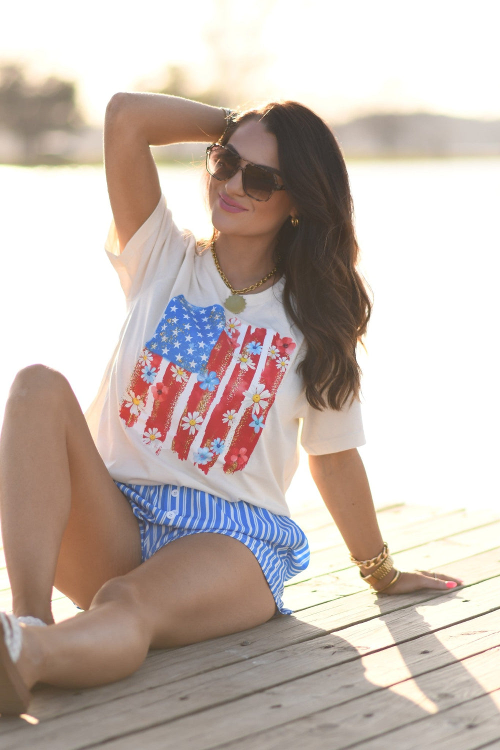 Woman wearing floral American flag graphic Bella Canvas unisex tee in natural color, patriotic floral Fourth of July shirt