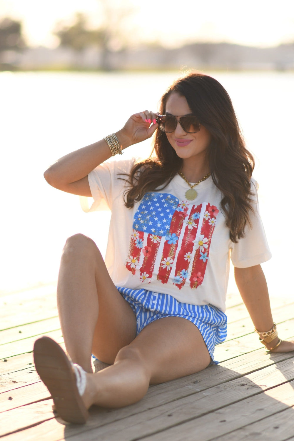 Woman wearing floral American flag graphic Bella Canvas unisex tee in natural color, patriotic floral Fourth of July shirt