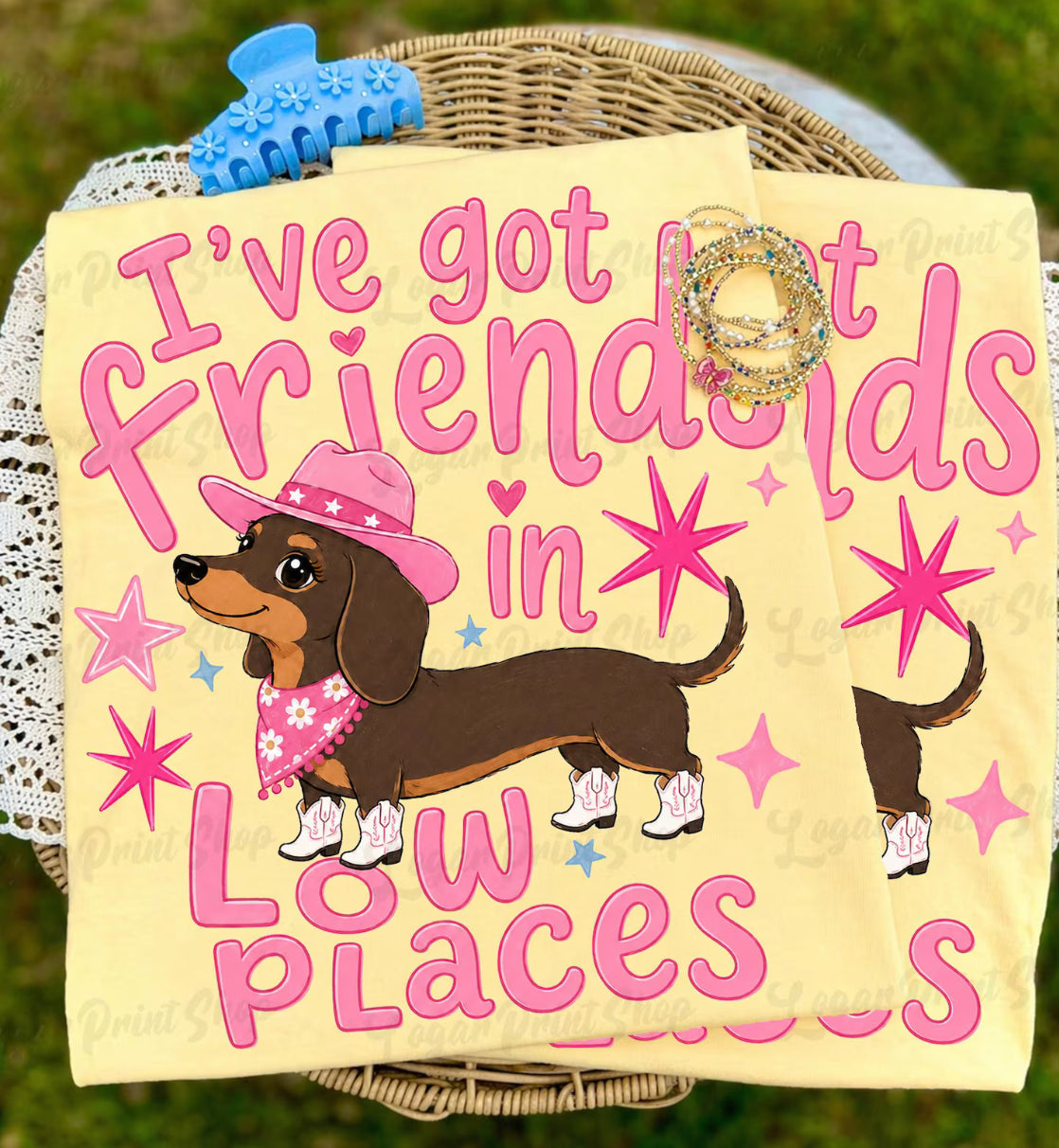 Butter yellow graphic tee with pink Friends In Low Places text, western dachshund dog wearing a pink cowgirl hat, bandana, and white boots.
