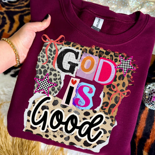 Burgandy shirt with 'God is Good' text and leopard print design held by a hand.
