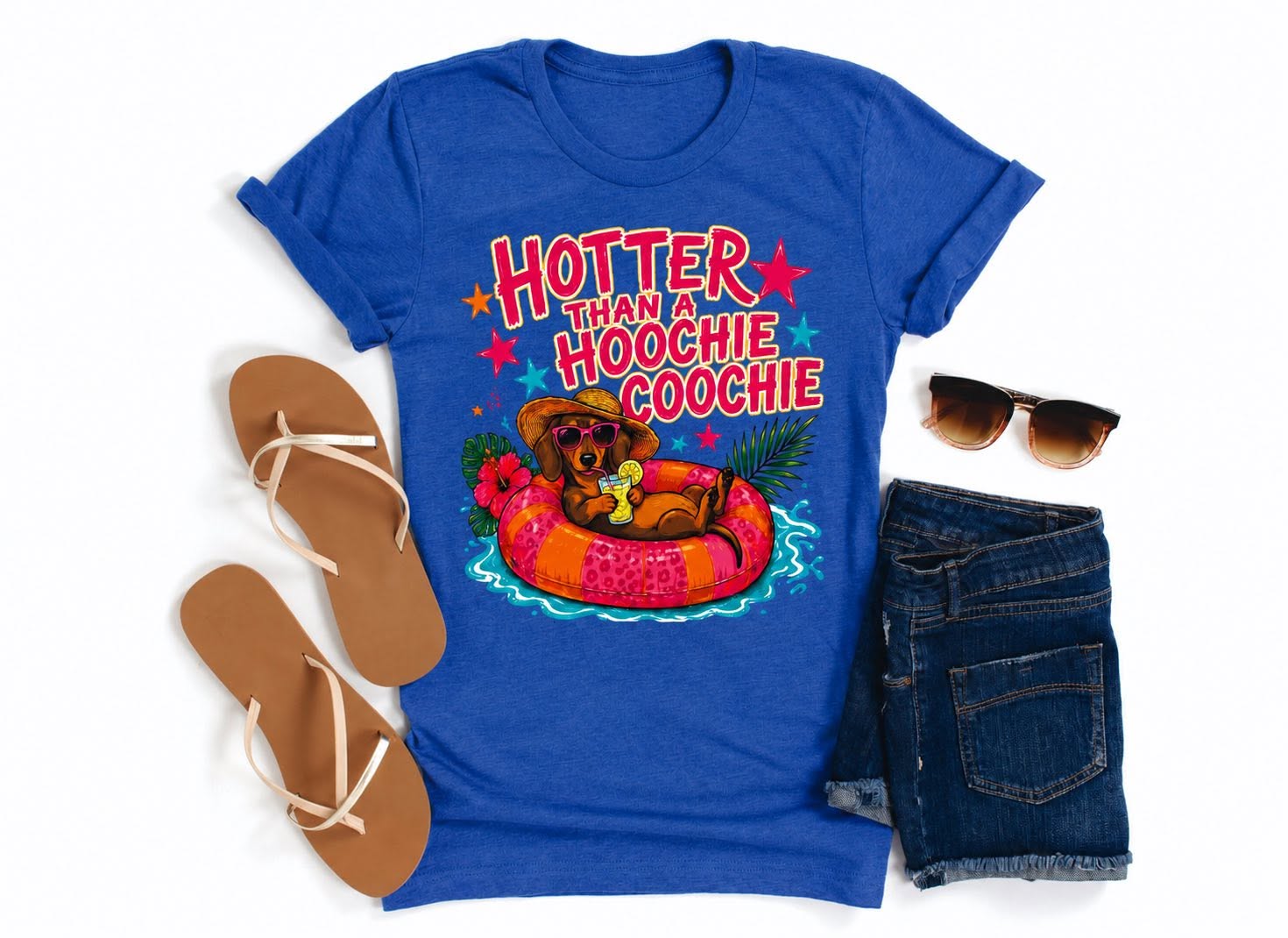 Blue summer graphic tee with Hotter Than a Hoochie Coochie design featuring a dachshund on a pool float, styled with shorts, sandals, and sunglasses.