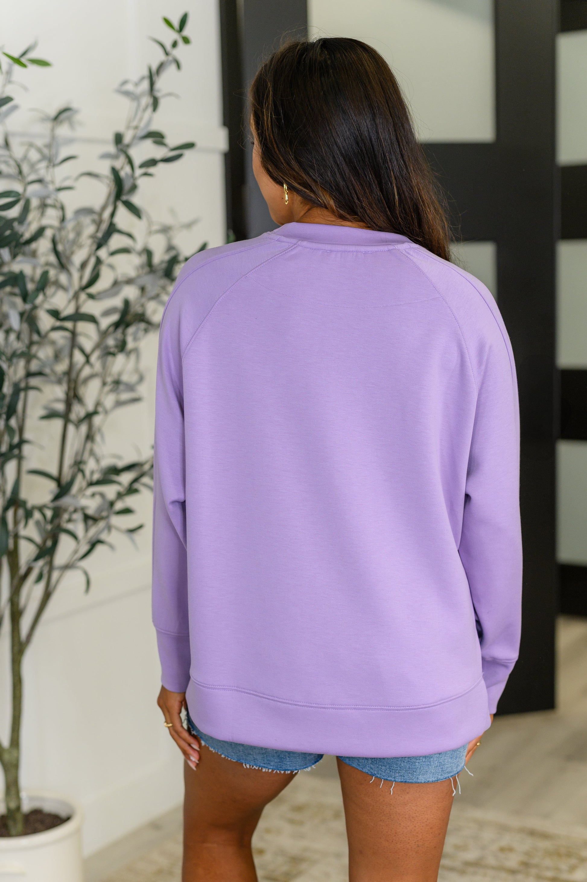 Lavender, relaxed scuba pullover with a round neckline, raglan sleeves, and side slits.
