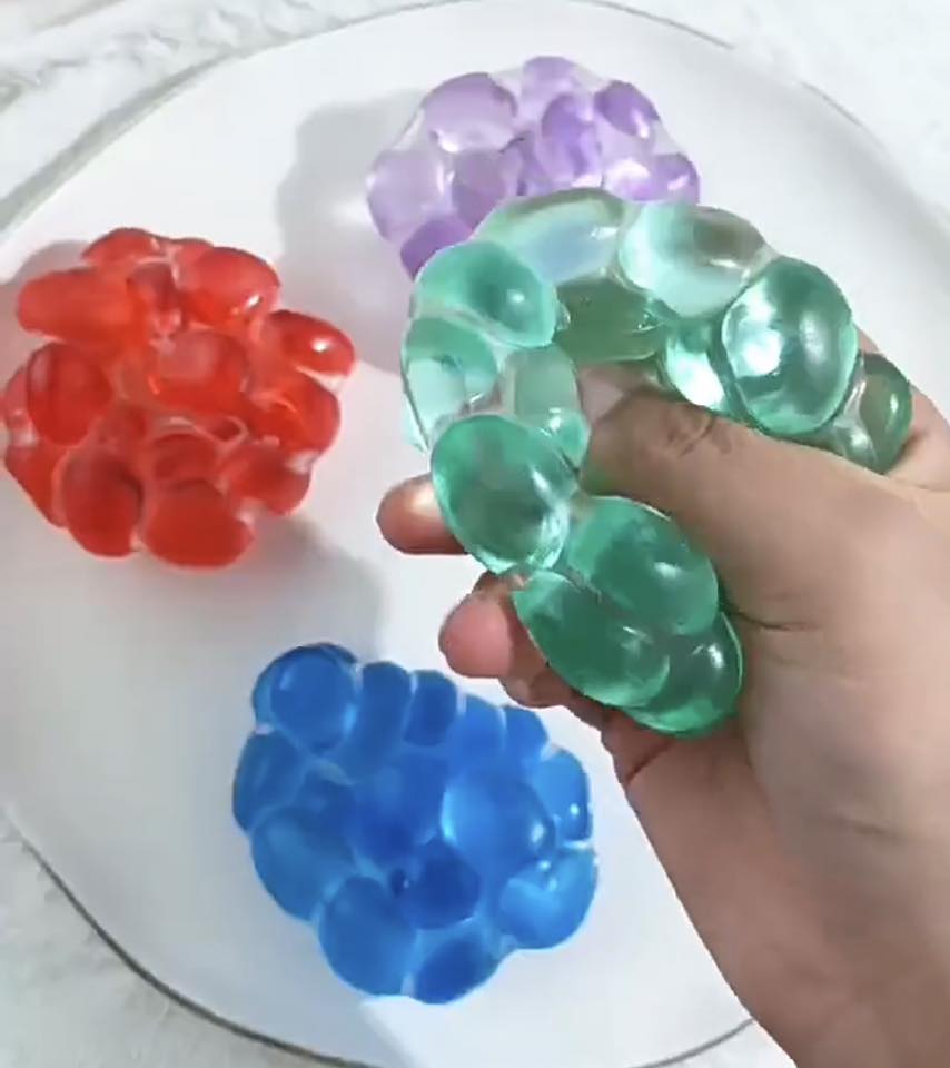 Colorful jelly bubble squishy toy being squeezed for stress relief sensory play