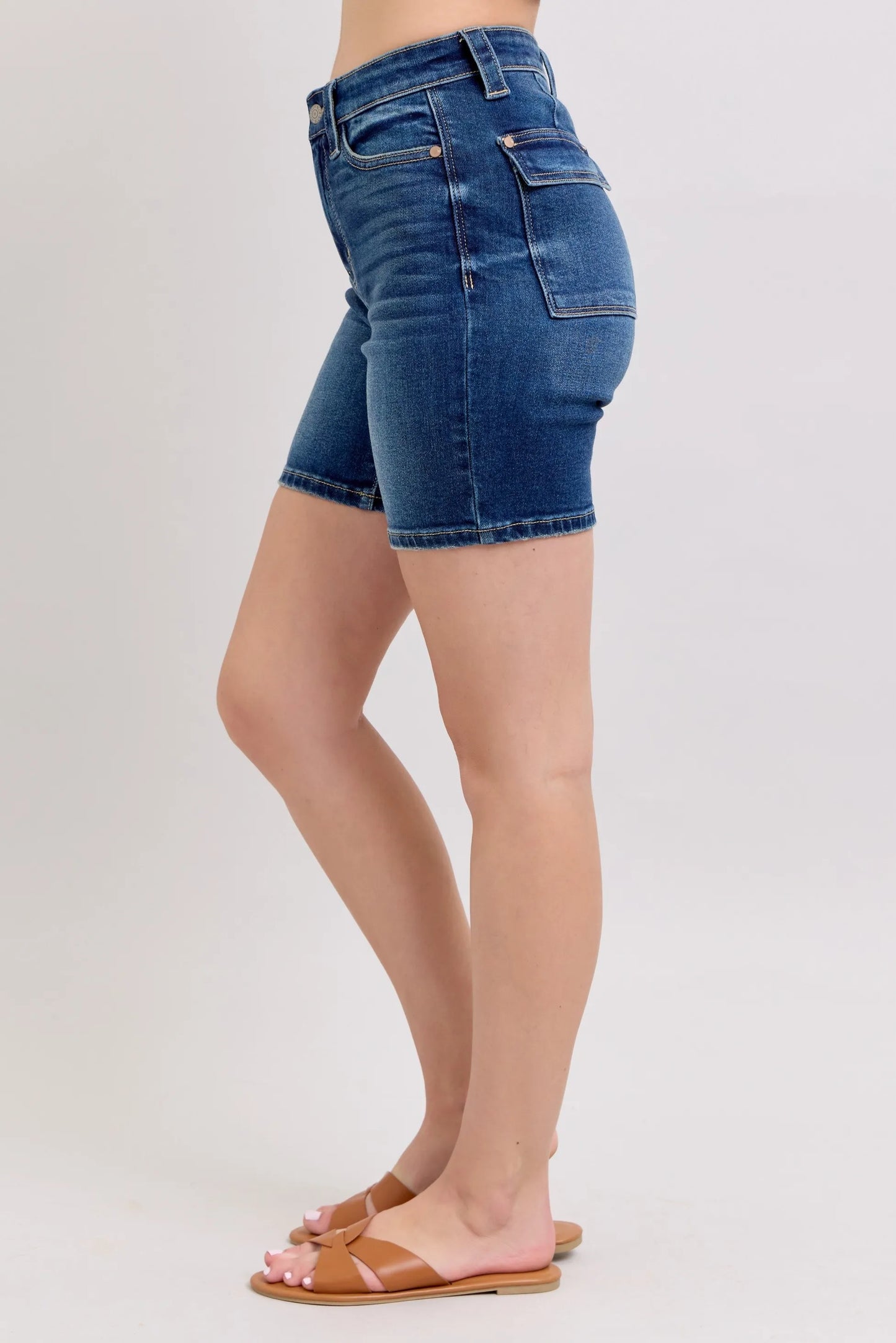 Model wearing Judy Blue high waist Bermuda denim shorts in mid-blue wash with back flap pockets and stretch fit