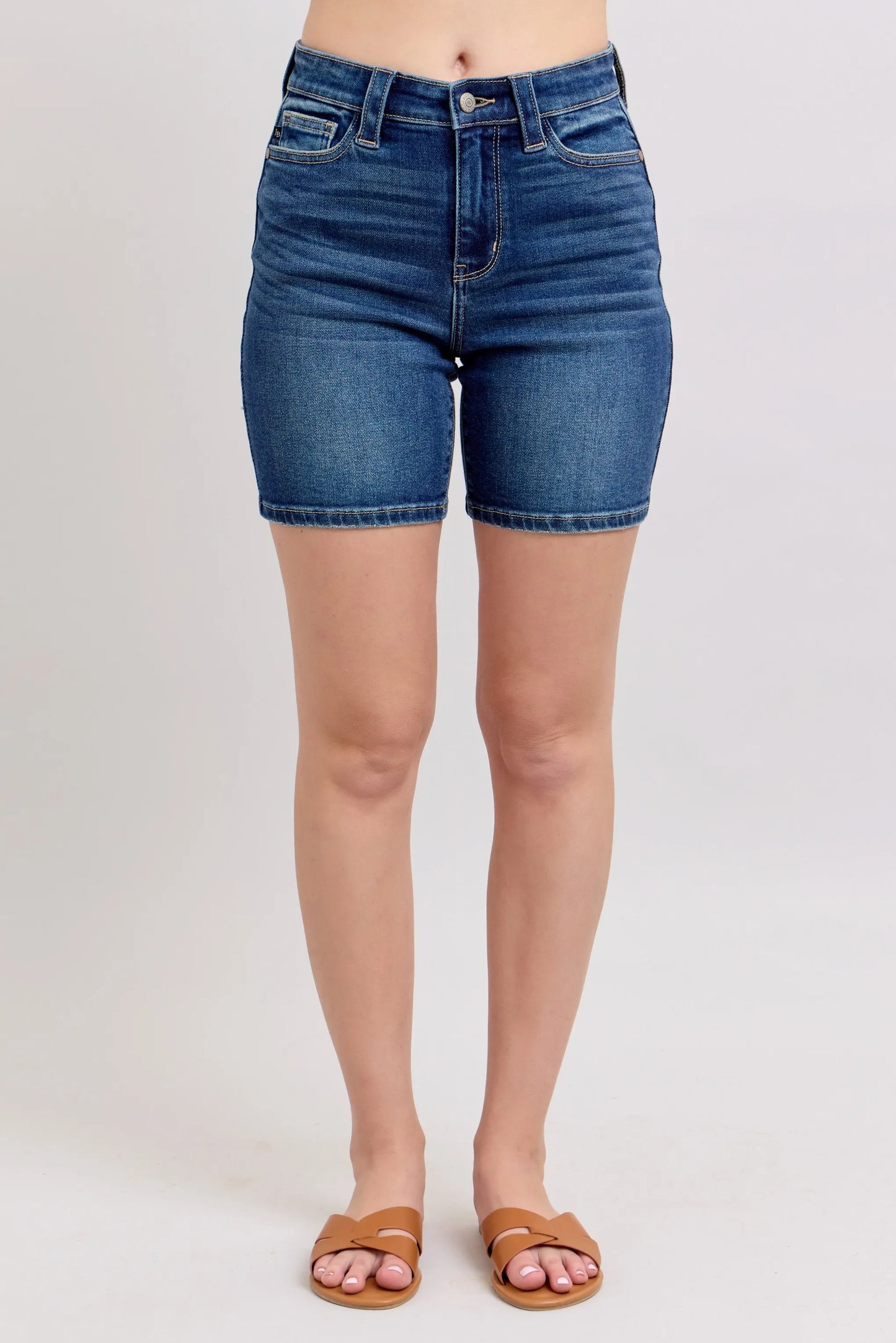 Model wearing Judy Blue high waist Bermuda denim shorts in mid-blue wash with back flap pockets and stretch fit