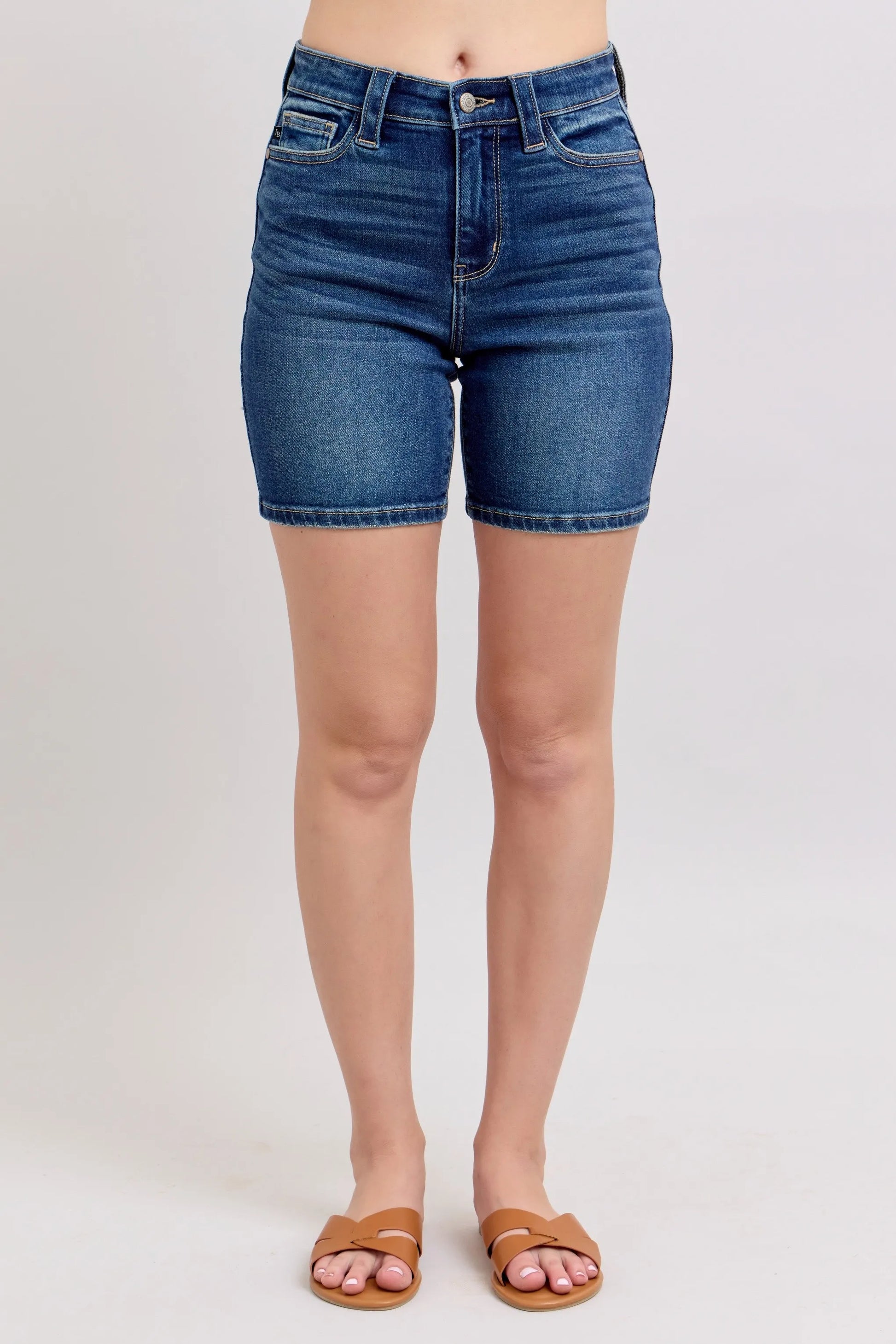 Model wearing Judy Blue high waist Bermuda denim shorts in mid-blue wash with back flap pockets and stretch fit