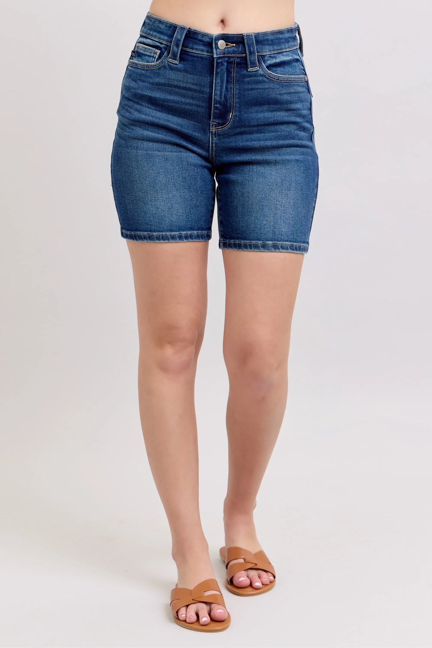 Model wearing Judy Blue high waist Bermuda denim shorts in mid-blue wash with back flap pockets and stretch fit