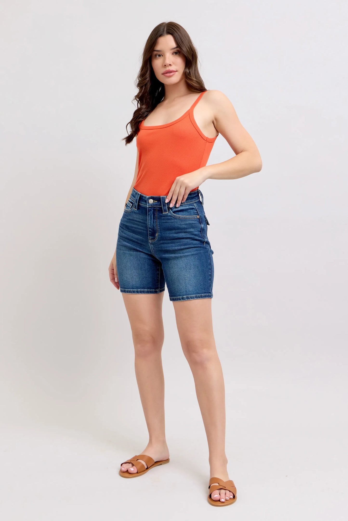 Model wearing Judy Blue high waist Bermuda denim shorts in mid-blue wash with back flap pockets and stretch fit