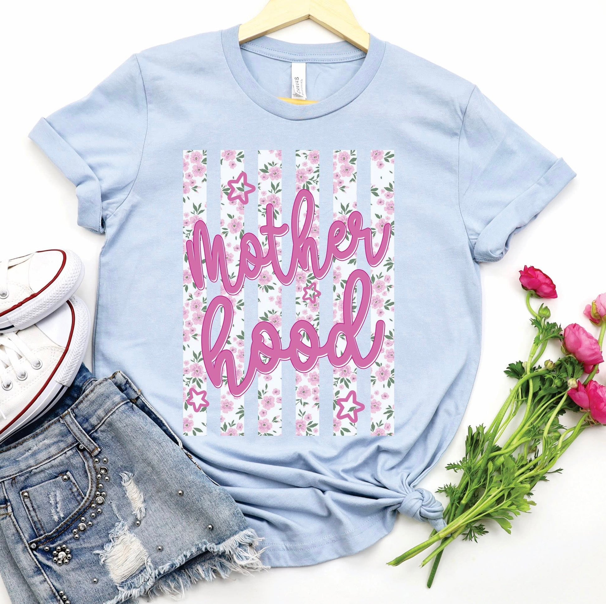 Floral Motherhood graphic t-shirt on light blue Bella Canvas tee styled with denim shorts and flowers