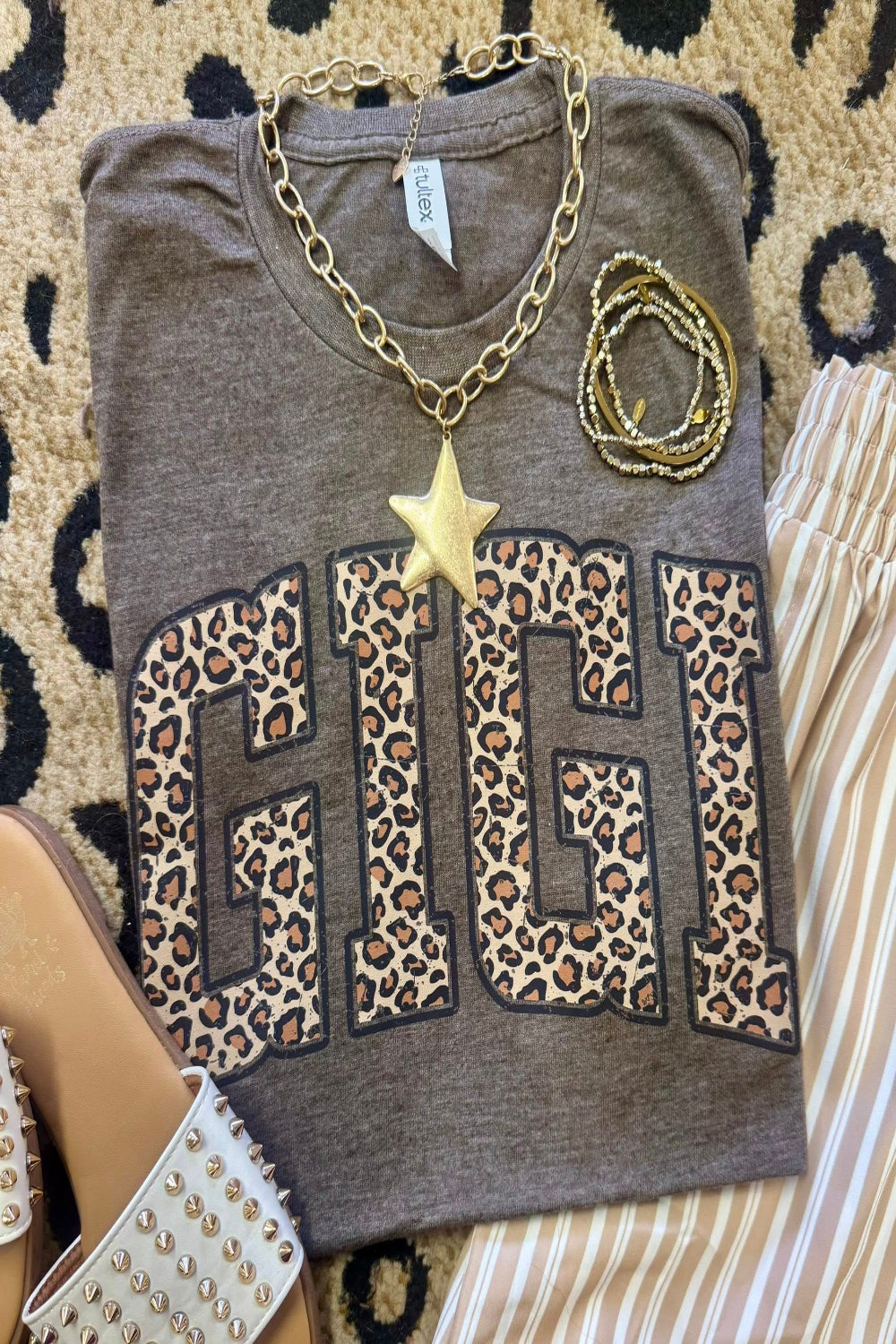 Leopard Gigi graphic tee on heather brown Tultex shirt styled with bracelets and neutral striped pants for a trendy Mother’s Day outfit.