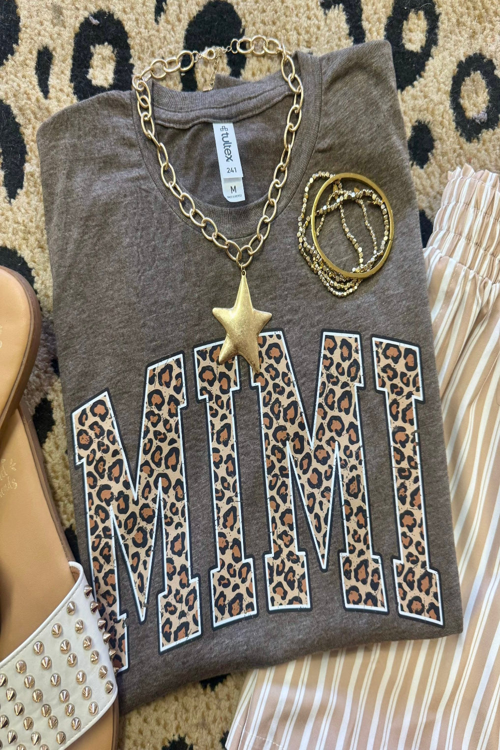 Leopard Mimi graphic tee on heather brown Tultex shirt styled with bracelets and neutral striped pants for a trendy Mother’s Day outfit.