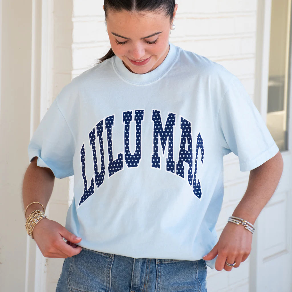 Person wearing a light blue t-shirt with 'LULUMAC' printed in dark blue letters.