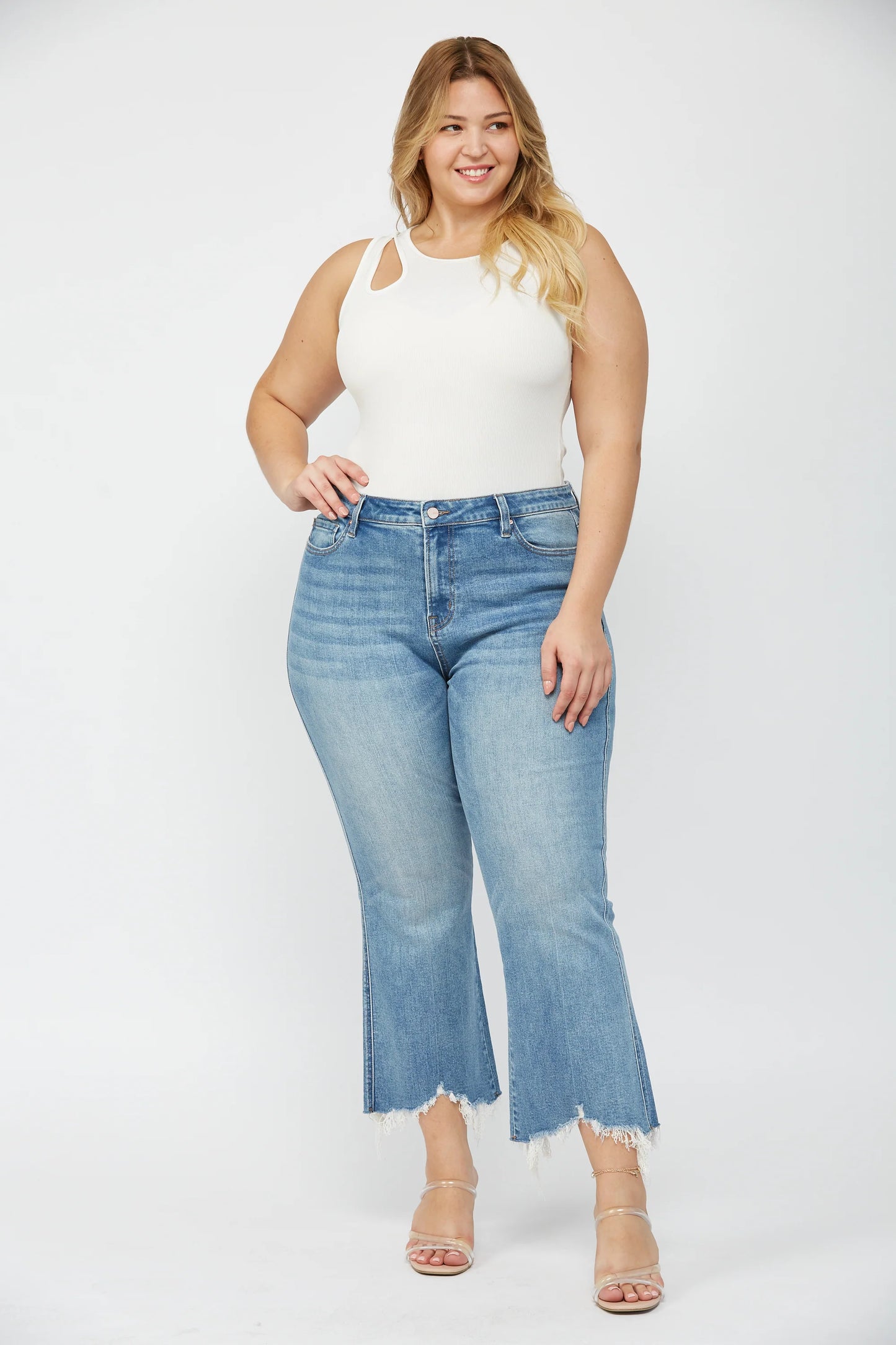Woman wearing MICA high rise crop flare jeans with uneven raw hem and stretch denim