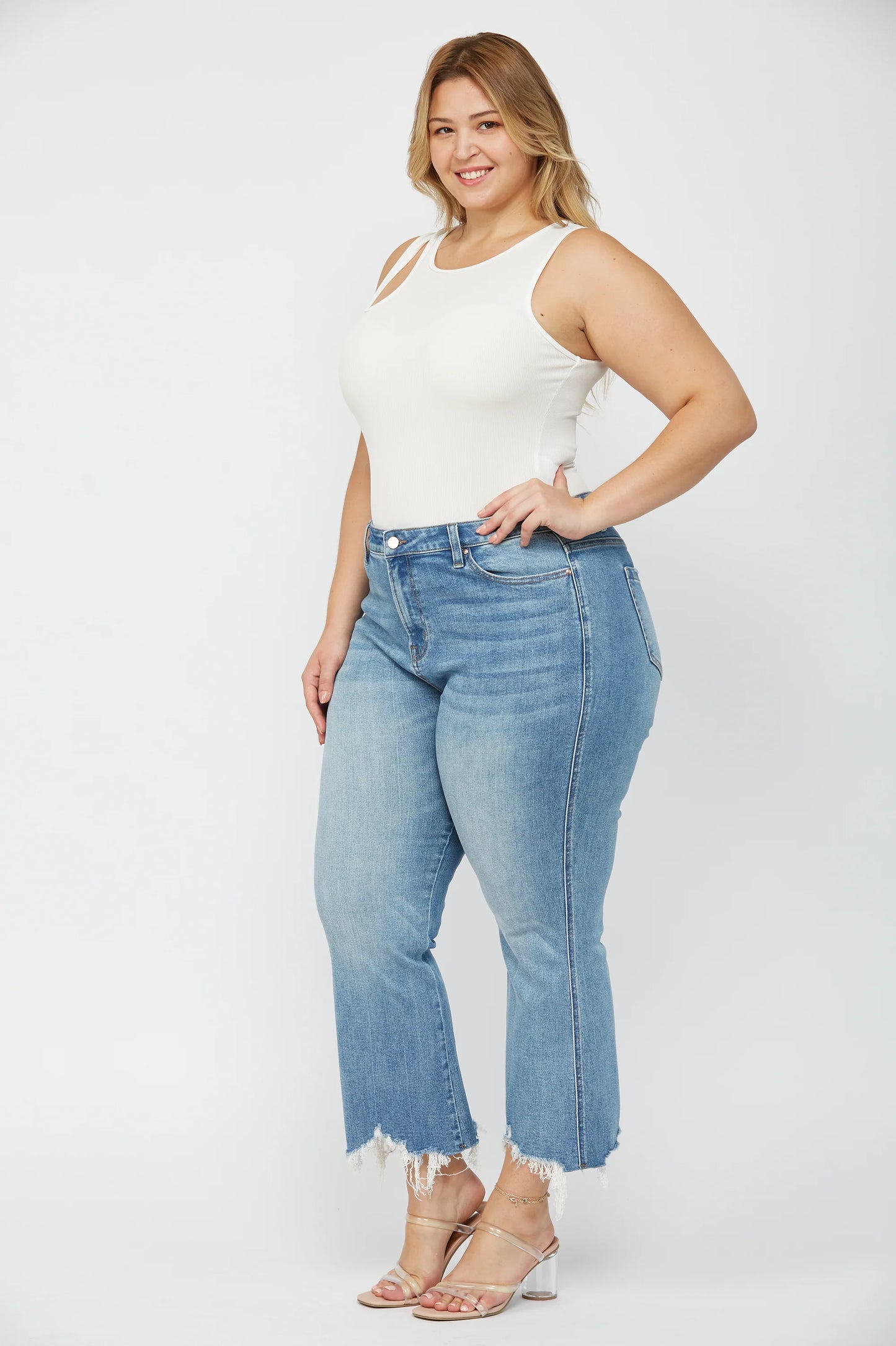 Woman wearing MICA high rise crop flare jeans with uneven raw hem and stretch denim