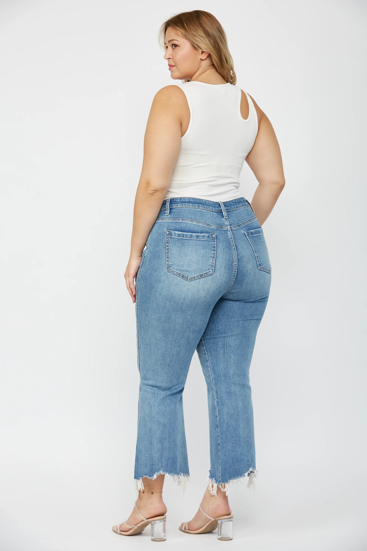 Woman wearing MICA high rise crop flare jeans with uneven raw hem and stretch denim
