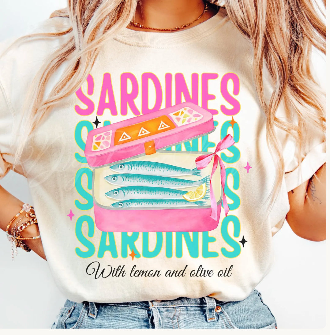 Neon beachy sardines graphic tee with retro pink sardine tin, lemon and olive oil design on a cream shirt.