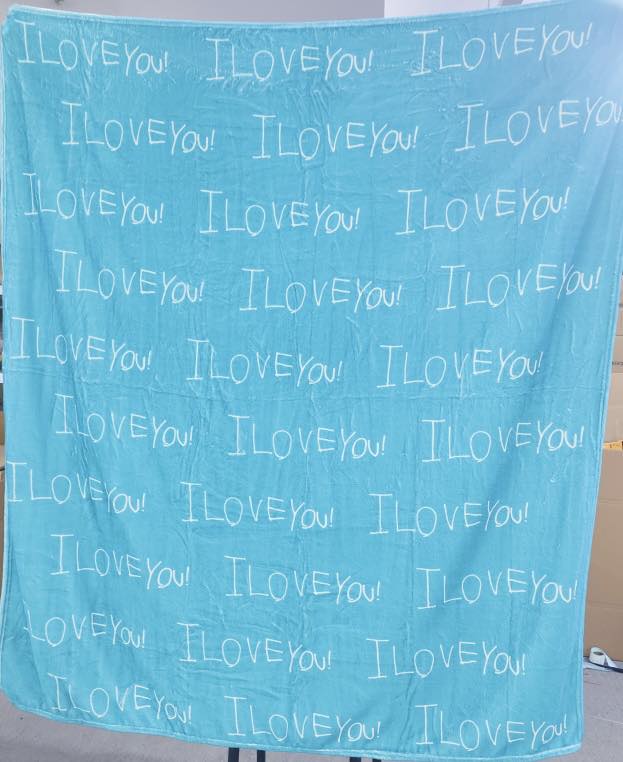 Custom handwriting blanket featuring child’s handwritten “I love you” repeated on a soft blue personalized keepsake blanket