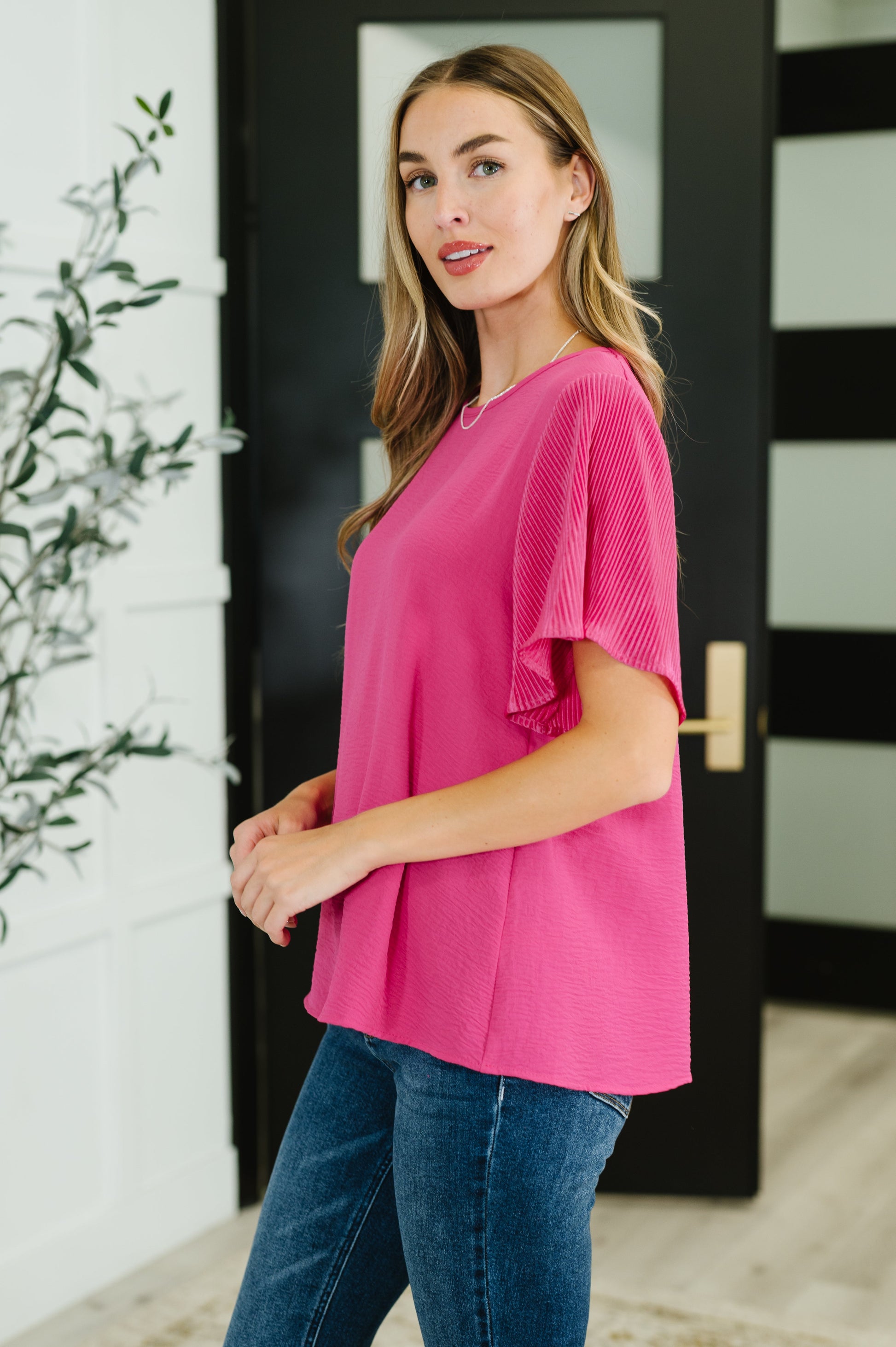 Pink ruffle sleeve top with a round neckline and short, pleated sleeves.