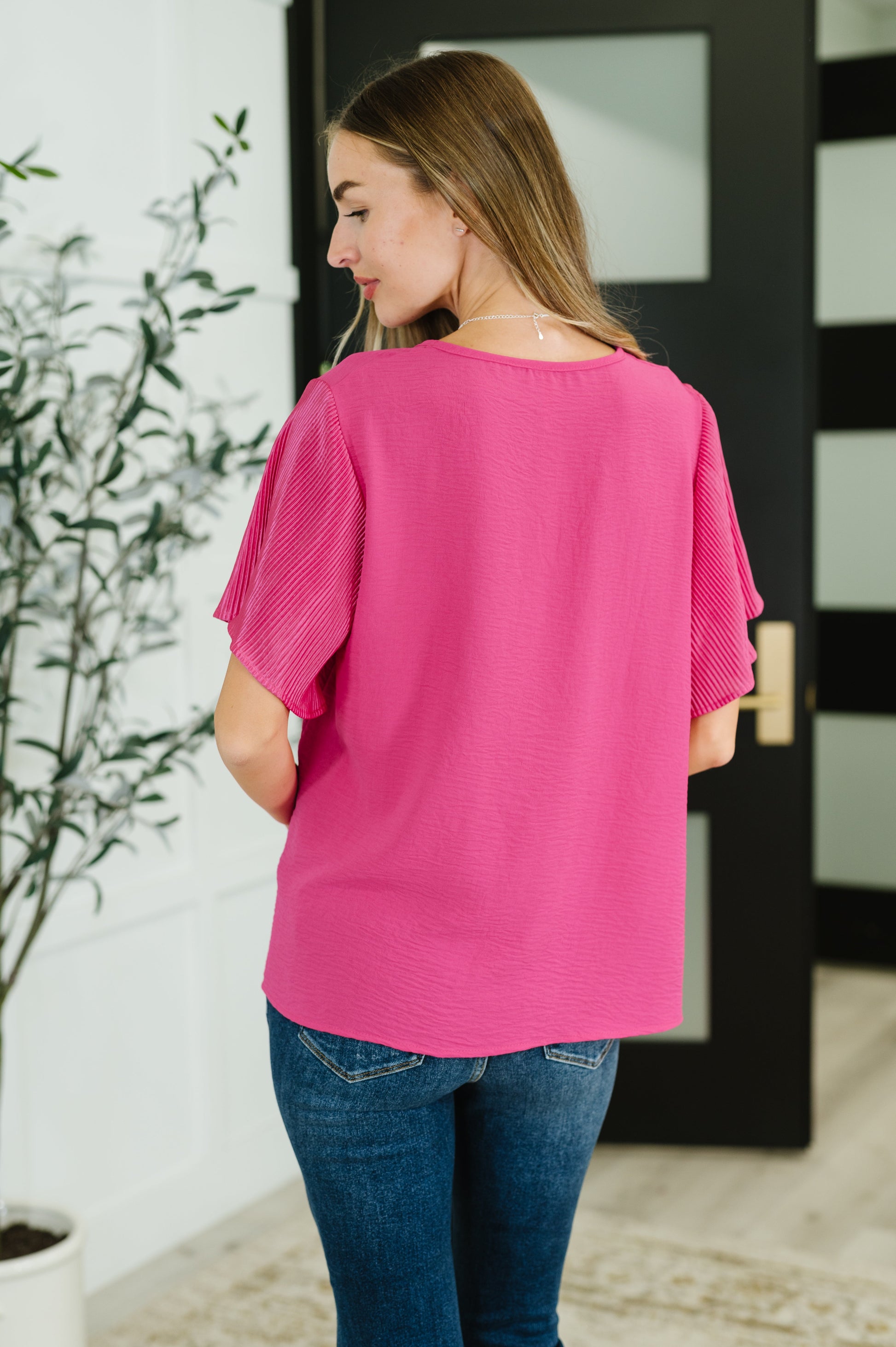 Pink ruffle sleeve top with a round neckline and short, pleated sleeves.